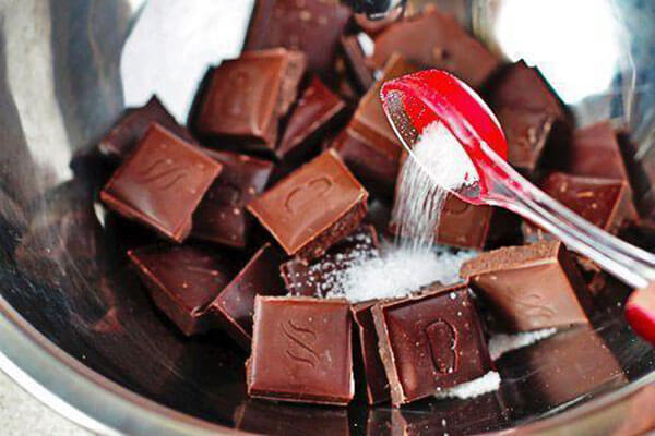 Шоколад наломаем кусочками и отправим в кастрюльку. Добавим сахар и молоко.