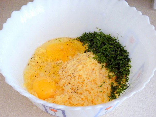 Натрём на средней тёрке сыр, измельчим зелень и добавим их в миску вместе с куриными яйцами.