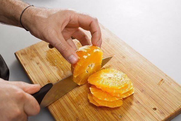 Для начала очистим апельсин от кожуры и плёнок. Одну четвертинку отложим. Остальное нарежем кружочками. Толщина должна составить около 0,5 см.