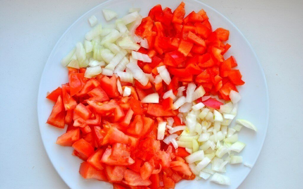Очистим все овощи. Мясо промоем и нарежем кубиками. Лук, помидоры и перец тоже нарезаем кубиками.