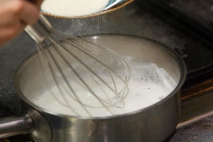 Доводим молоко до кипения. Добавим манку, сахар и соль, перемешаем венчиком. Часто перемешиваем и варим до загустения.