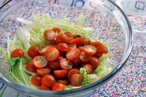 Промоем помидоры и нарежем их половинками. Кладём в салатник вместе с пекинской капустой.
