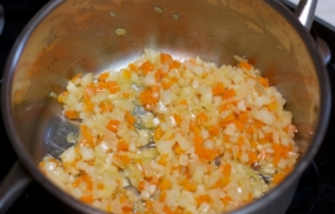 В кастрюльке растопим сливочное масло. а после обжарим на нём уже ранее нарезанные овощи в течение 10 минут.