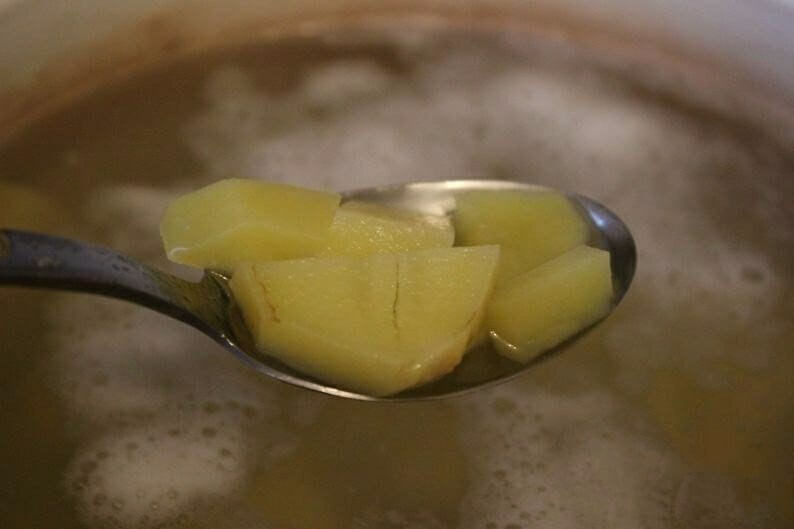 Картофель очищаем и нарезаем небольшими кубиками. Воду (бульон) доводим до кипения, если нужно добавляем соль, перец по вкусу. Отправляем картошку вариться до закипания.