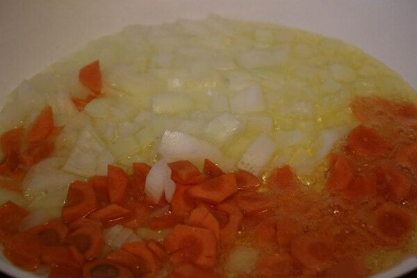 Лук измельчаем, а морковь нарезаем небольшими кусочками. Смазываем сковороду растительным маслом и разогреваем. Сначала до золотистого цвета обжарим лук, а затем добавим морковку.