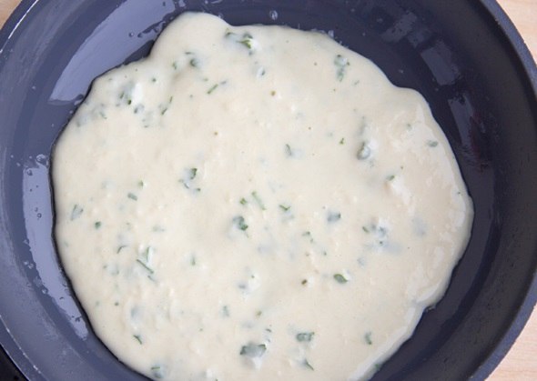 Твёрдый сыр натрём на мелкой терке, а зелень нашинкуем острым ножом помельче. Добавьте все это в тесто и тщательно смешаем.