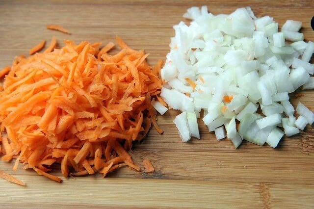 Морковь очистить, промыть и натереть на крупной тёрке. Луковицу очистить и нарезать мелкими кубиками.